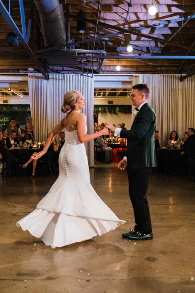 Photo of a couple dancing at their wedding while the bride's dress twirls.